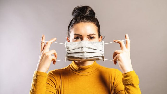 Woman putting a face mask on