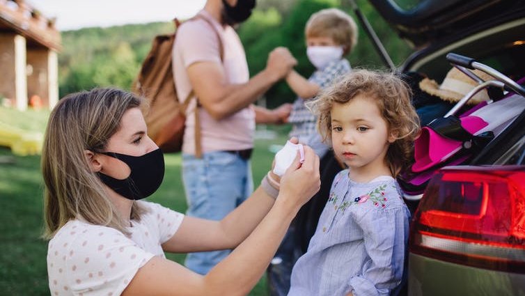 A family of four, putting on their masks while out in the countryside