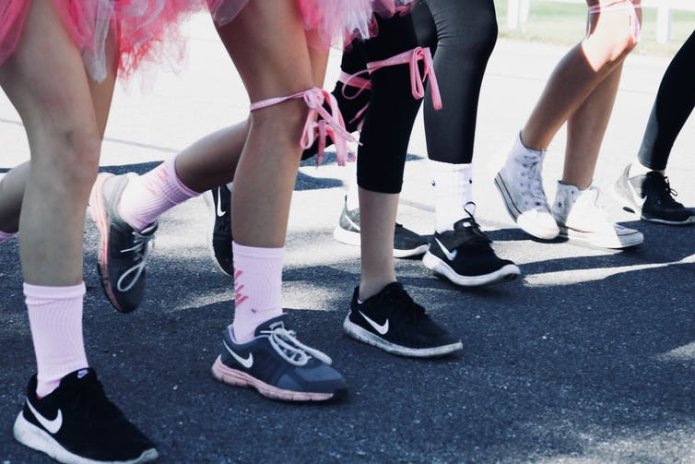 Close up of legs wrapped in pink ribbons waiting to start a race