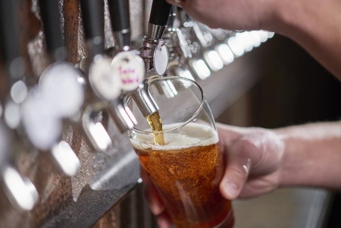 A person pouring a pint of beer at a bar