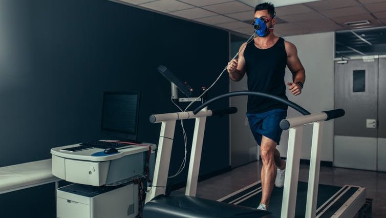 Male athlete having VO2 max test on treadmill.