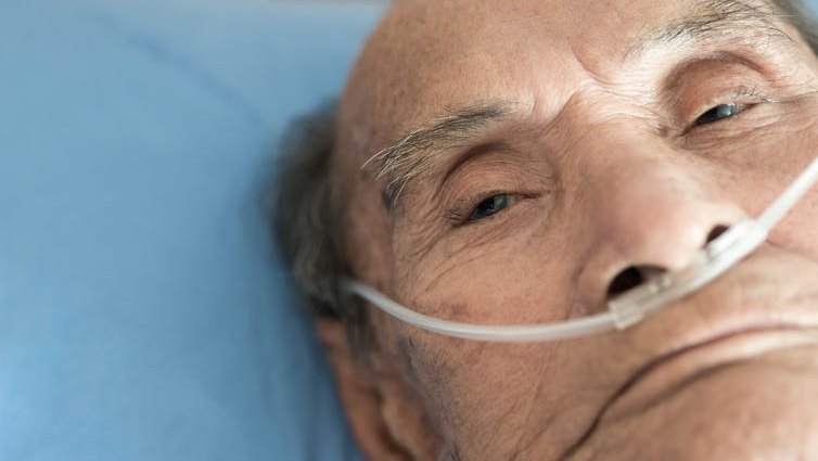 An elderly man receiving supplemental oxygen.