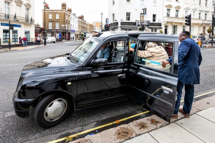 People getting into a London taxi.