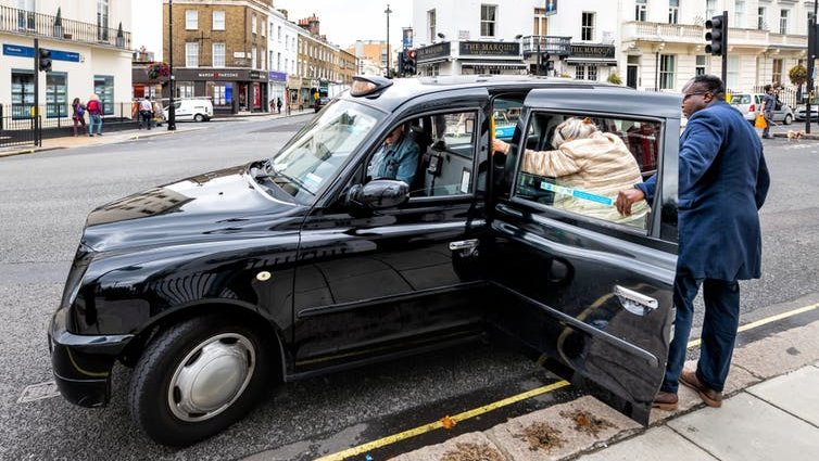 People getting into a London taxi.