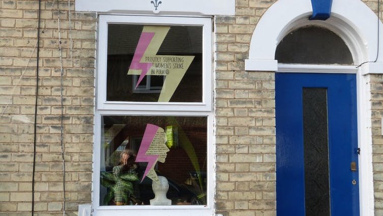 A lightning bolt sign in the window of a terraced house.