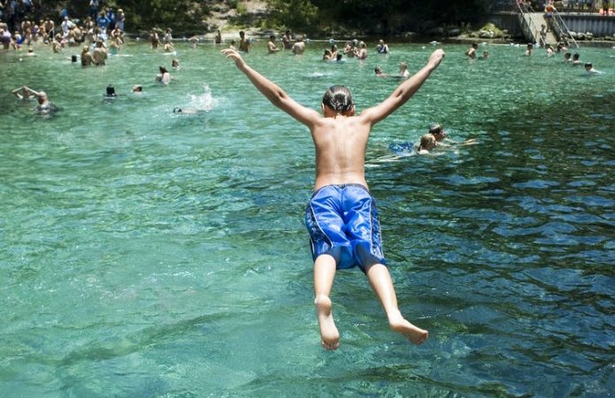 Picture of a man belly flopping into water.