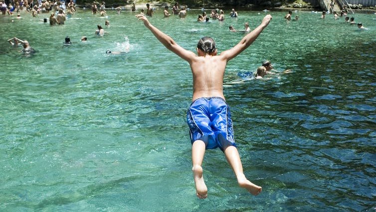 Picture of a man belly flopping into water.