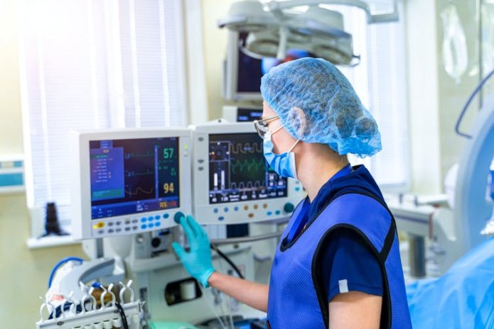 A nurse operating a ventilator