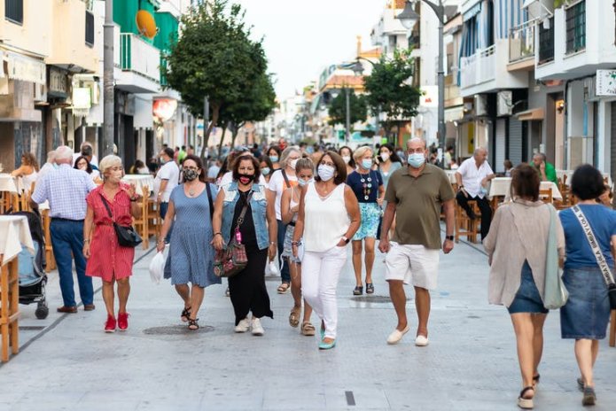 People in masks walking down a street