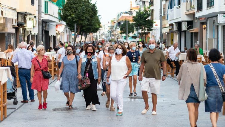 People in masks walking down a street