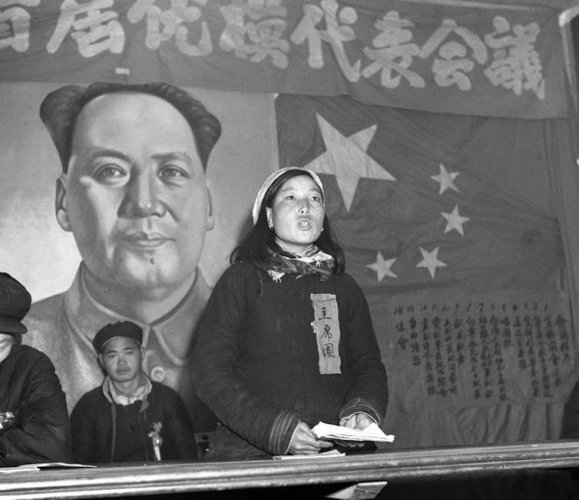 Shen Jilan makes a speech in front of the Chinese flag.