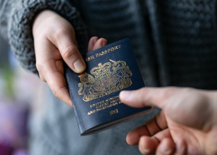 A person handing or taking away a British passport