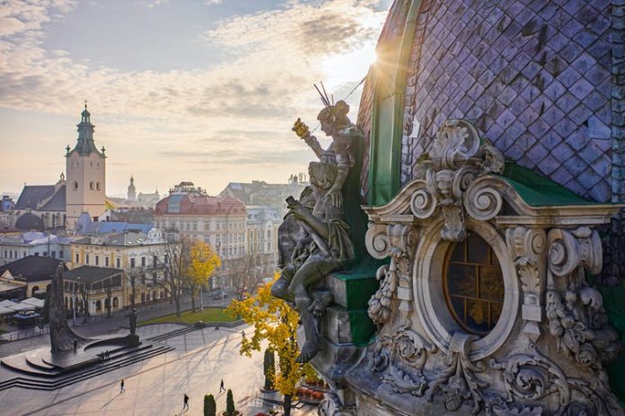 Sculpted roofs and a public plaza seen at sunset.