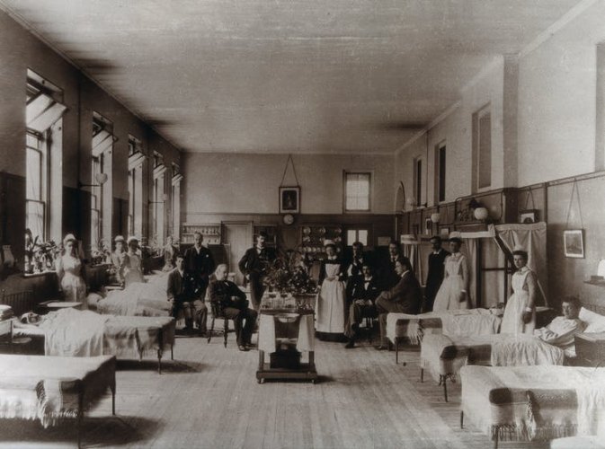 A scene in a 19th century hospital ward, in black and white.