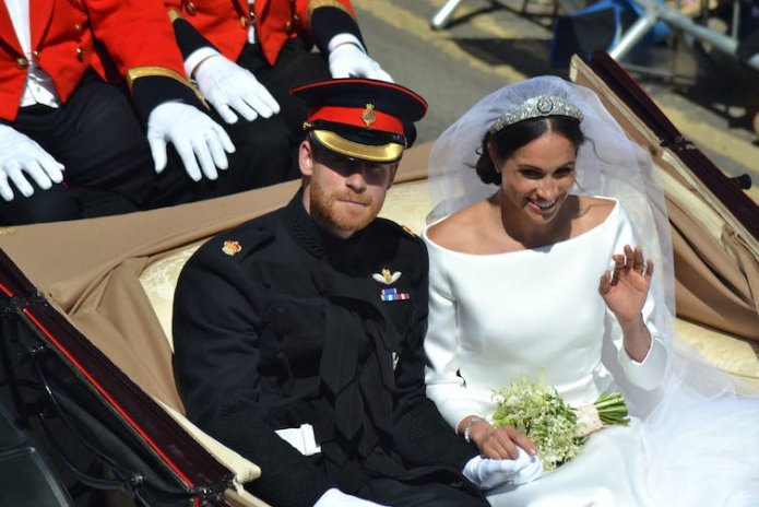 A bridal couple in an open-topped carriage.