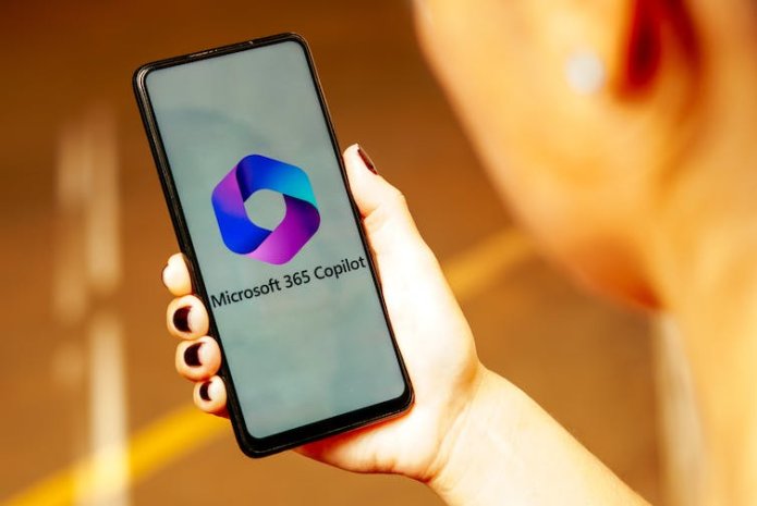 The Microsoft 365 Copilot logo is displayed on a smartphone screen held in a hand.