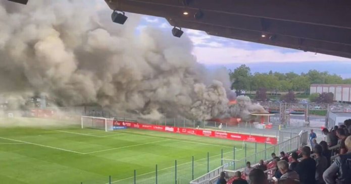 Football stadium evacuated after huge fire with smoke pouring over pitch