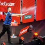 Luke Humphries throws water over fans after whistling in Luke Littler final