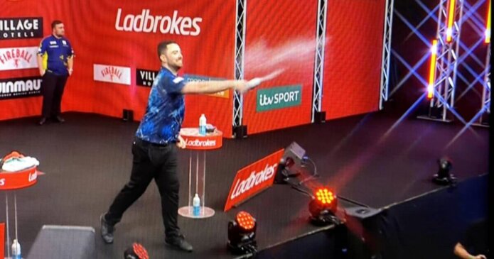 Luke Humphries throws water over fans after whistling in Luke Littler final