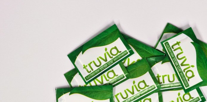 A man reaching for a protein bar in a shop.