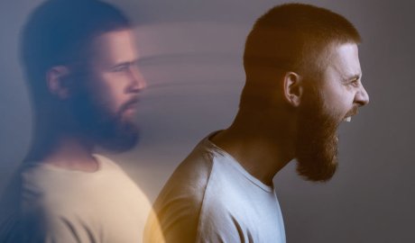 Angry furious businesswoman working on computer, screaming with alphabet letter coming out of open mouth