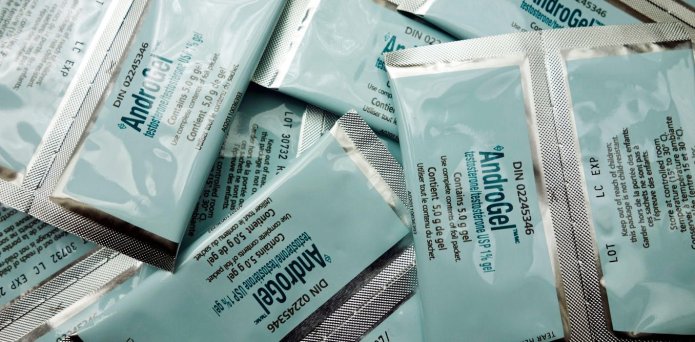 A man points to the prostate gland (orange) which sits below the bladder (red).