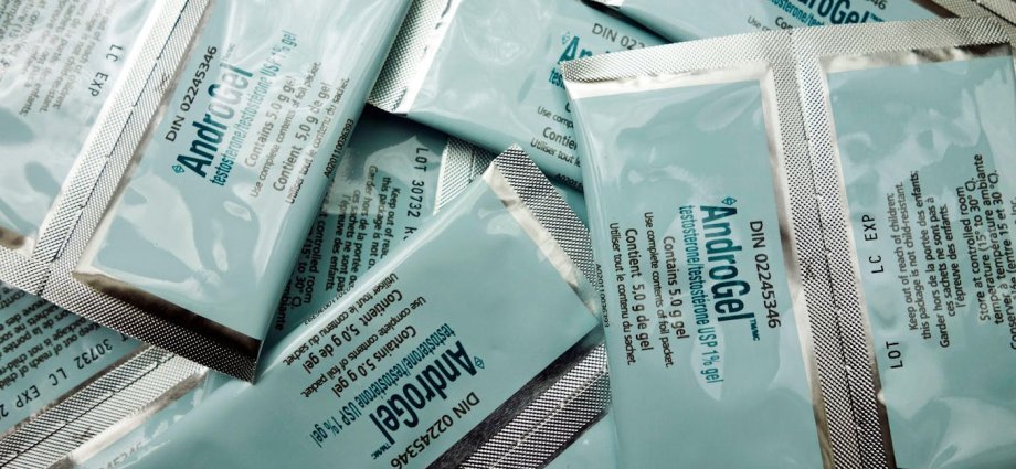 A man points to the prostate gland (orange) which sits below the bladder (red).